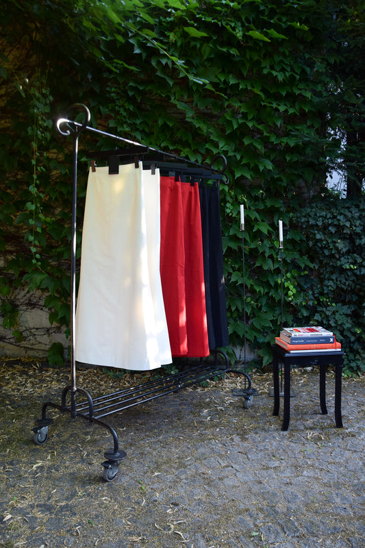 Sereine Skirt in Rot, Schwarz und Weiß auf Kleiderstange im Garten – handgefertigter Rock aus der Kollektion The New Luxury von PALAIS du SOLEIL