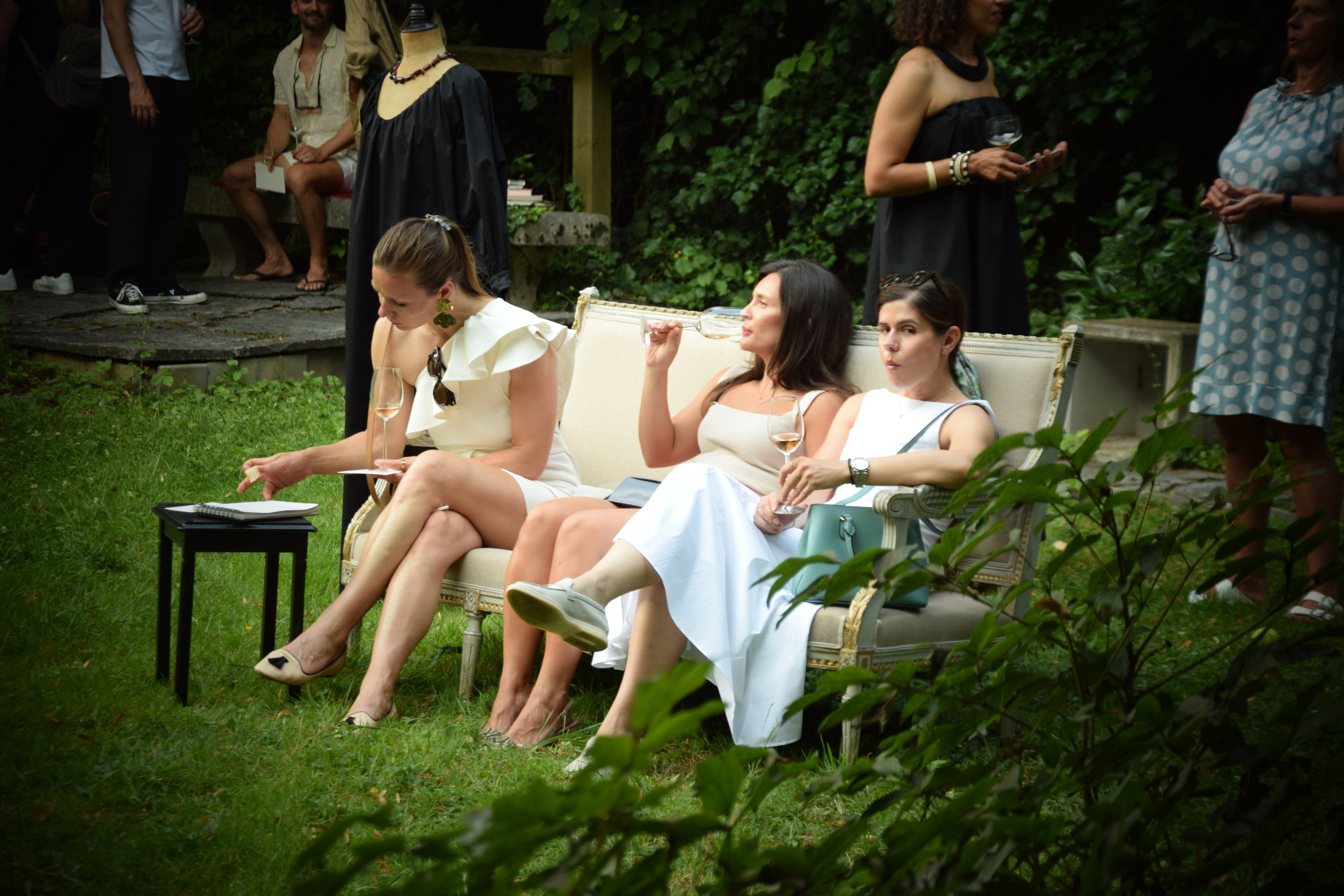 Gäste entspannen auf Vintage-Sofas bei der Garten-Soirée von PALAIS du SOLEIL – Launch der Kollektion The New Luxury